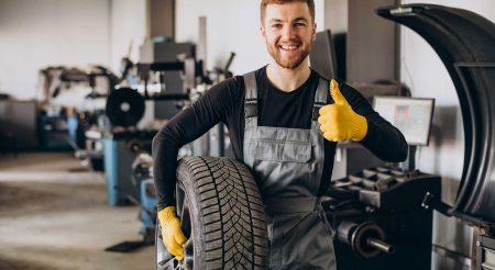 mechanic working with tyre changing equipment in the garage